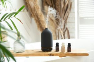 A selection of essential oil bottles on a table with a diffuser.